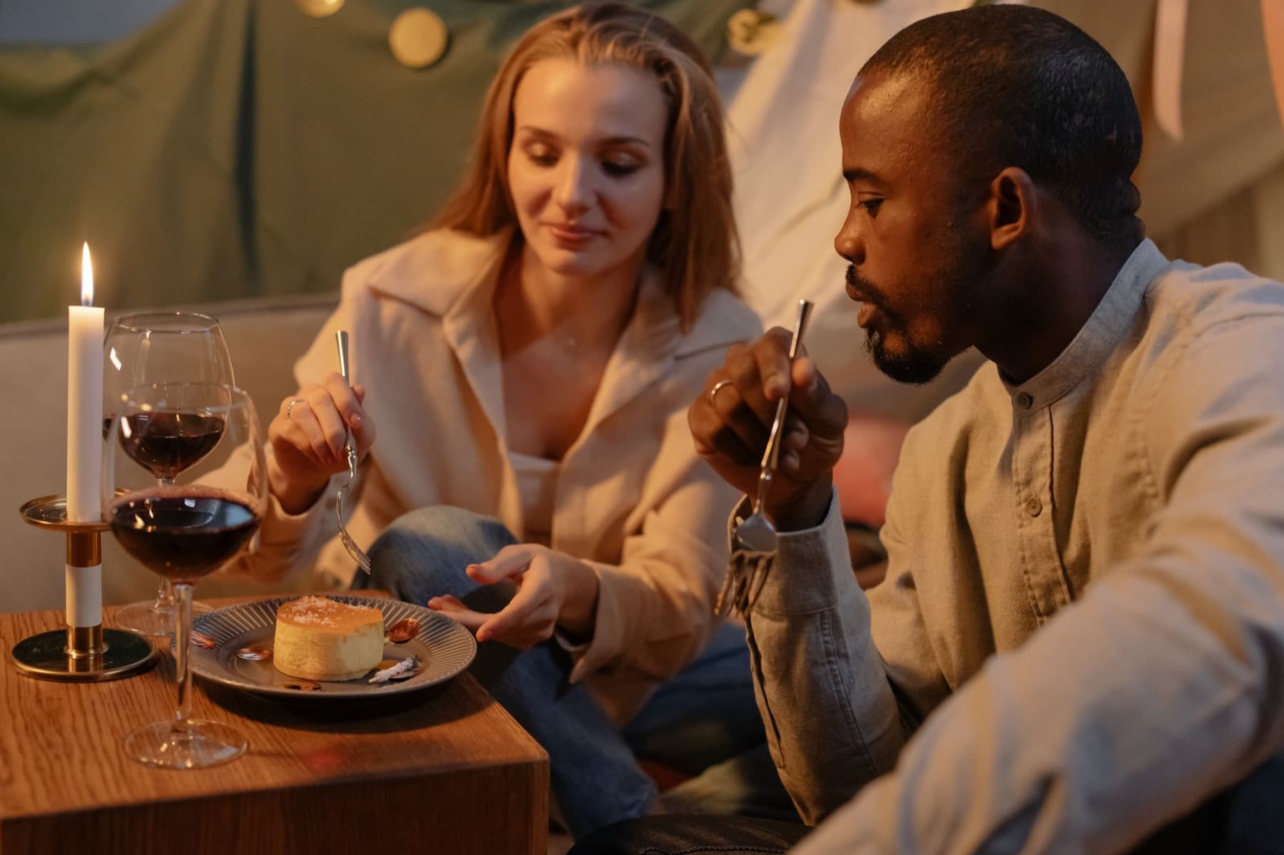A couple sharing dessert at a candlelit dinner