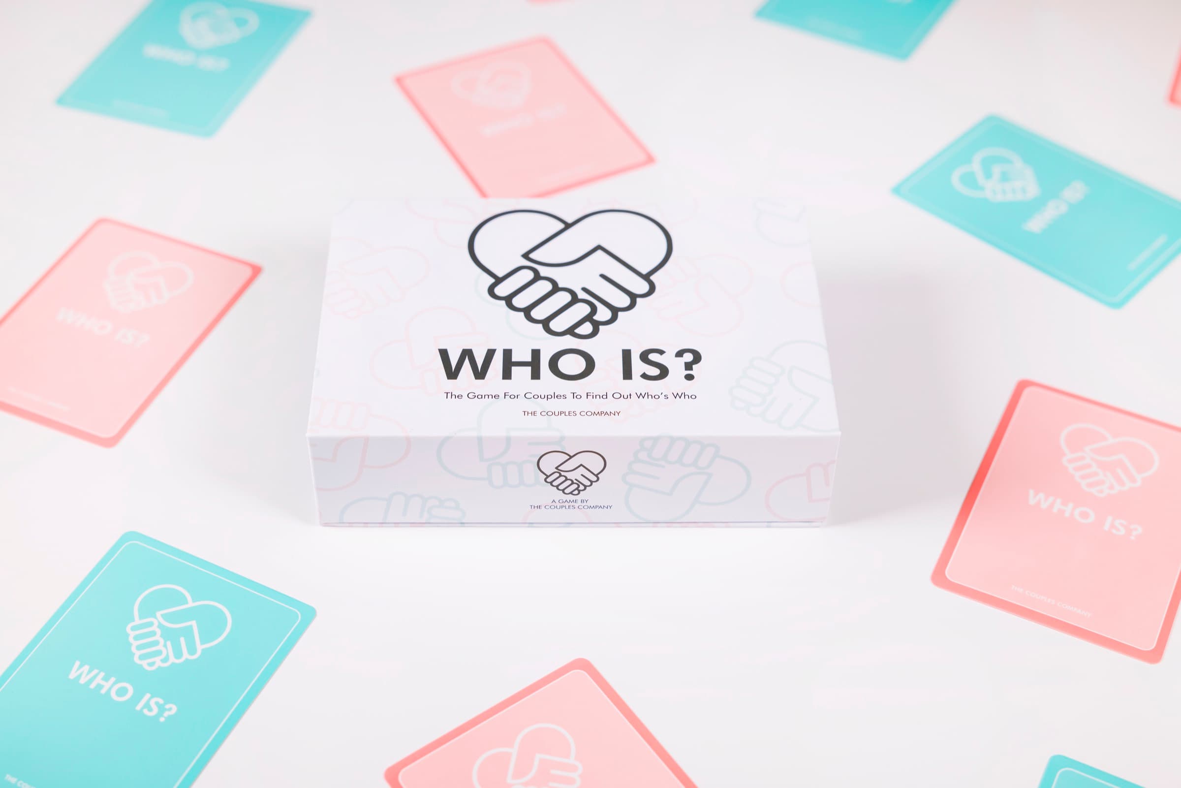 The WhoIs? card game box with pink and teal cards scattered around it